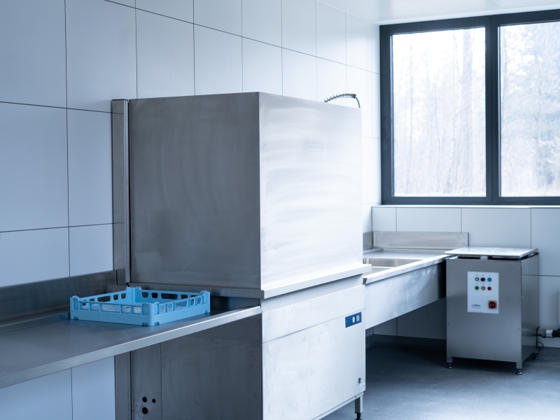 Spülzeile mit auf Wandkonsolen montierter Zu- und Ablaufplatte in Edelstahl